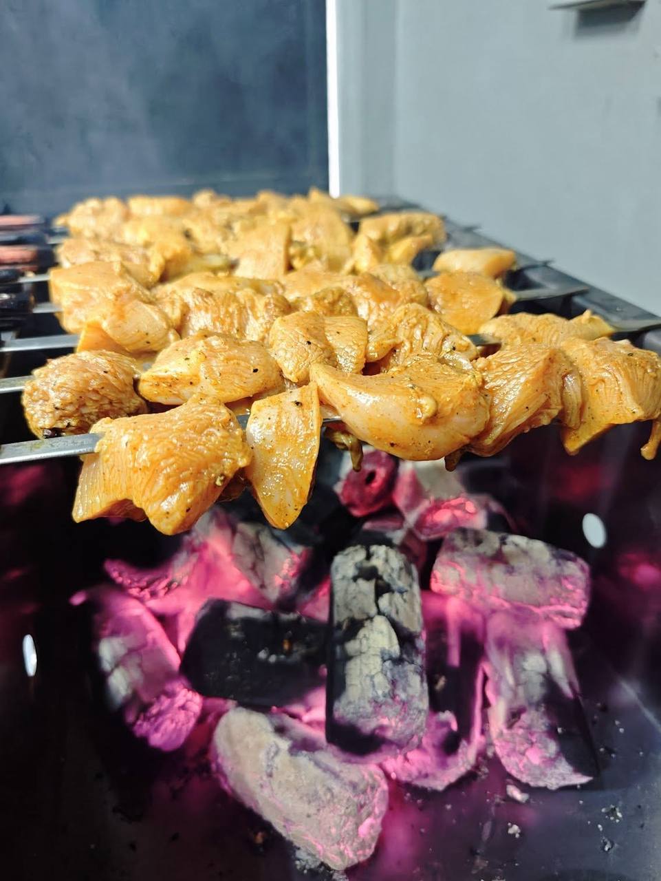 Shish tawook chicken skewers grilling over charcoal
